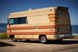 Vintage RV. American flag, RV, automotive, beach, beach umbrella, camper, camper van, dog, trailer, van conversion, vehicle, vintage trailer.