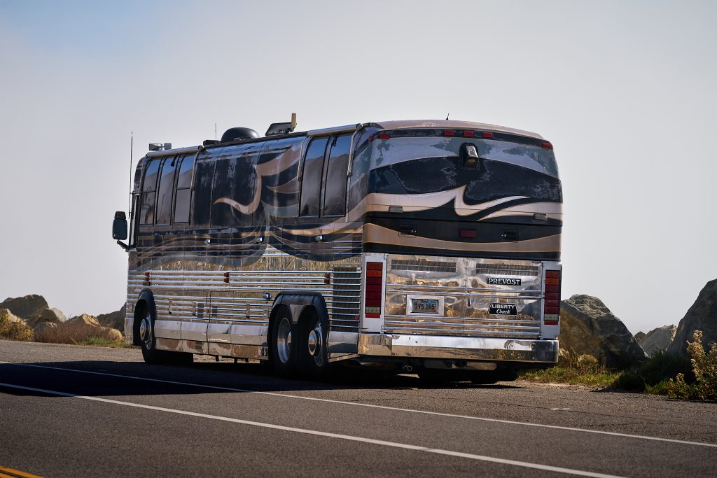Vintage Tour Bus. American flag, RV, automotive, beach, beach umbrella, camper, camper van, dog, americana, trailer, van conversion, vehicle, vintage trailer.