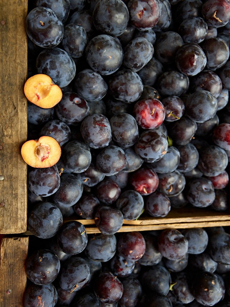 Split Plum. farmers market, fruits, food, still life, onions, organic, produce, vegitables, yellow onions.